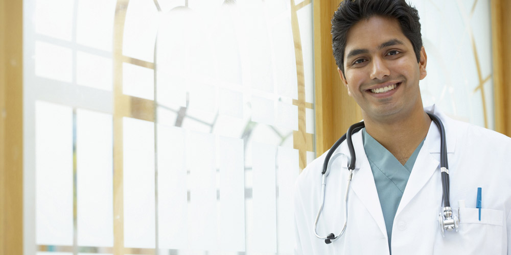 Indian doctor standing in front of a bright window